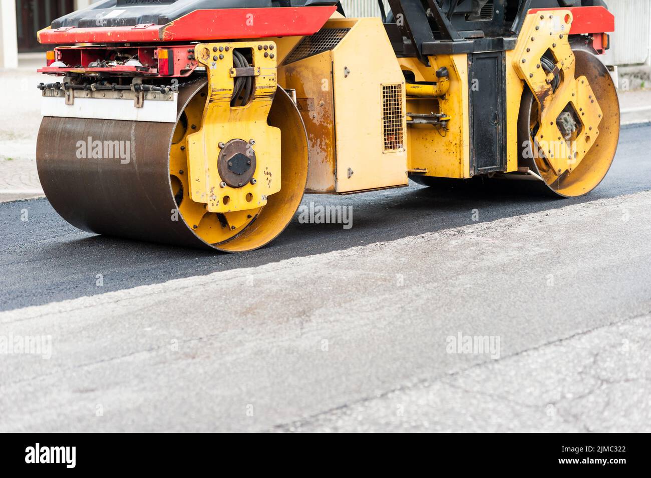 Straßenwalze bei der Arbeit. Arbeit der Asphaltierung einer Straße. Stockfoto