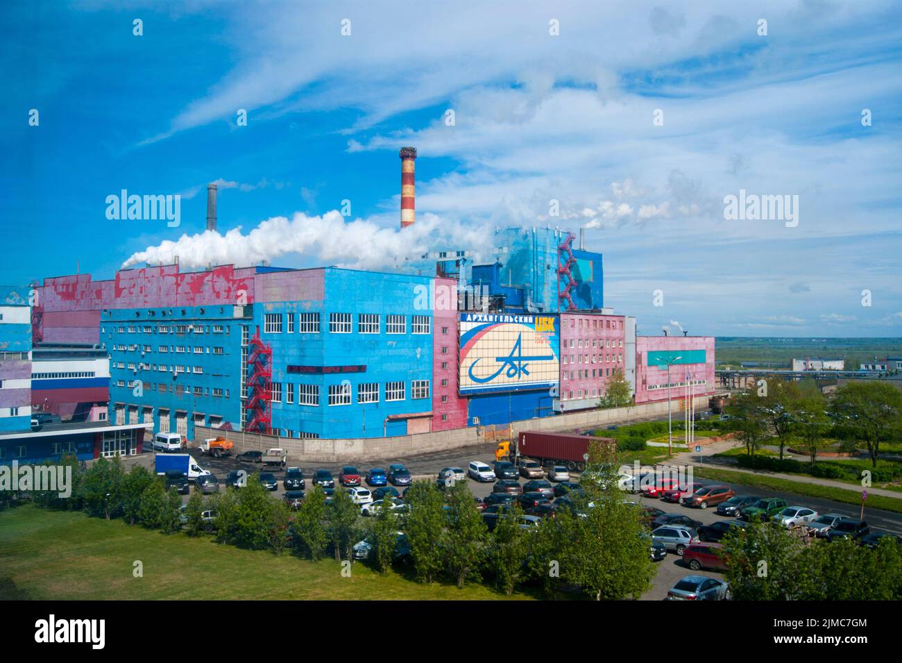 Sommer Industrielandschaft - Archangelsk Zellstoff und Papierfabrik, zentrale Uhr, weißer Rauch aus den Rohren gegen den blauen Himmel, e Stockfoto