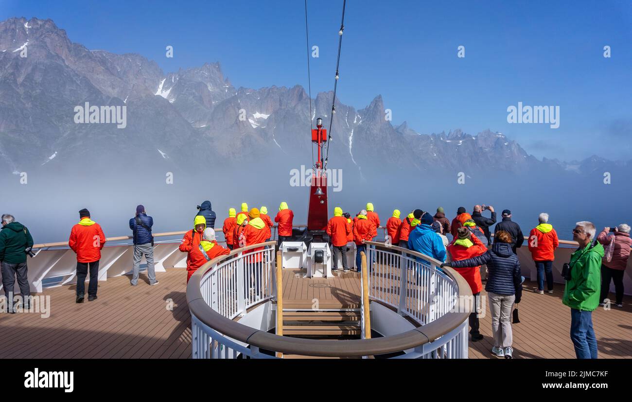 Passagiere versammelten sich auf der vorderen Aussichtsplattform in roten und gelben Jacken und genossen die arktische Landschaft auf der Hurtigrutens MS Fridtjof Nansen in Prince Stockfoto