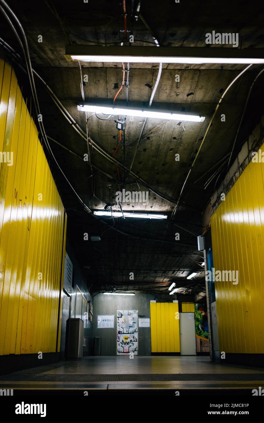 Eine vertikale Aufnahme einer heruntergekommenen Station mit gelben Wänden und freiliegender Decke Stockfoto