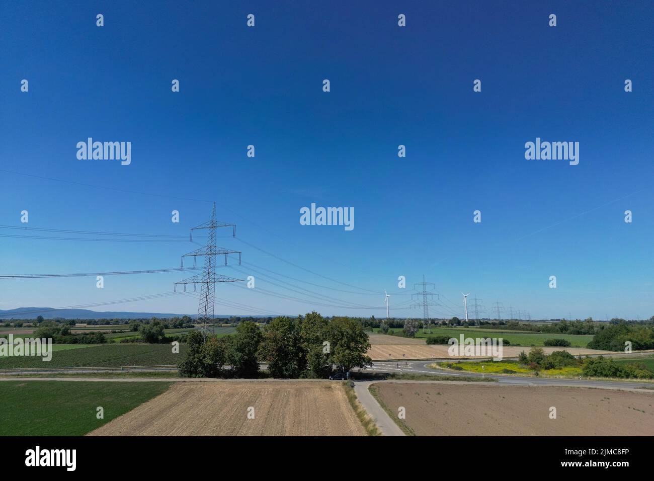 Energie, Deutschland, Rheinland-Pfalz, August 03. Höherer Blick auf eine Überland Stromleitung mit Windkraft Anlagen im Hintergrund. Stockfoto