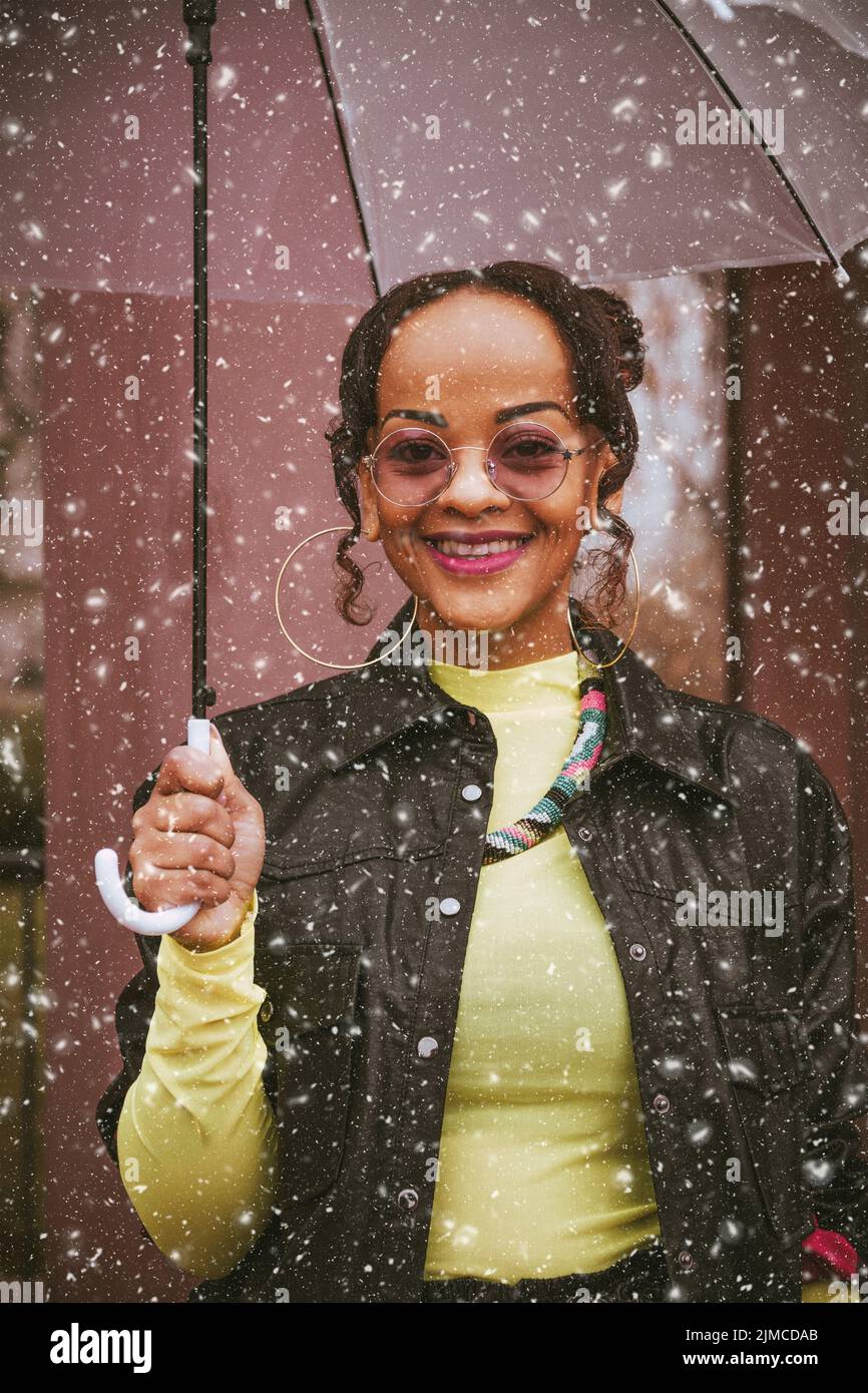 Eine afroamerikanische Frau unter einem Regenschirm Stockfoto