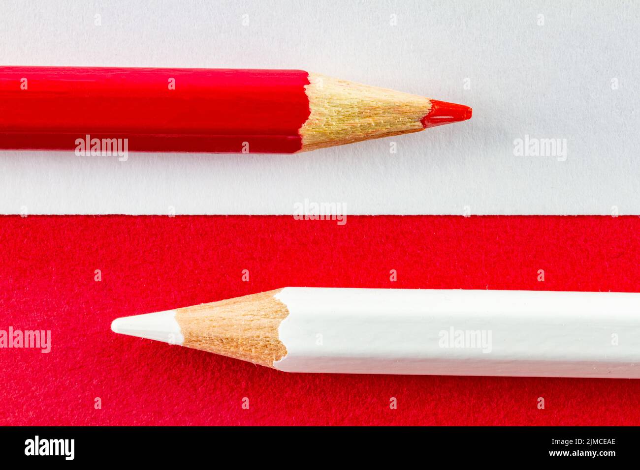 Farbstifte auf rot-weißem Farbpapier, horizontal angeordnet. Stockfoto