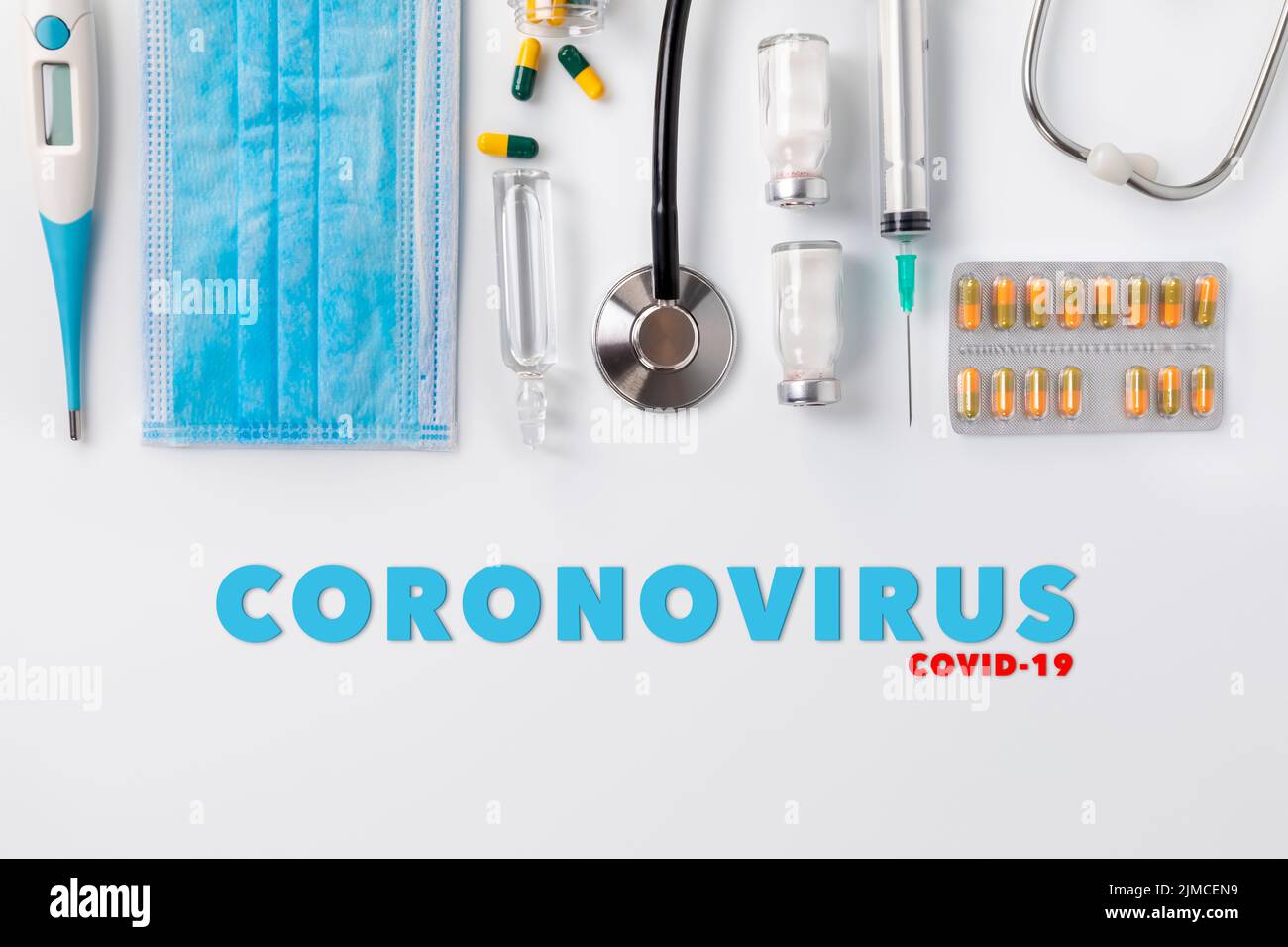 Schutzmasken, Medikamente, Thermometer, Stethoskop und Spritze mit Coronavirus-Text auf weißem Hintergrund Stockfoto Schutzmasken, Medikamente, Thermometer, Stethoskop und Spritze mit Coronavirus-Text auf weißem Hintergrund Stockfoto