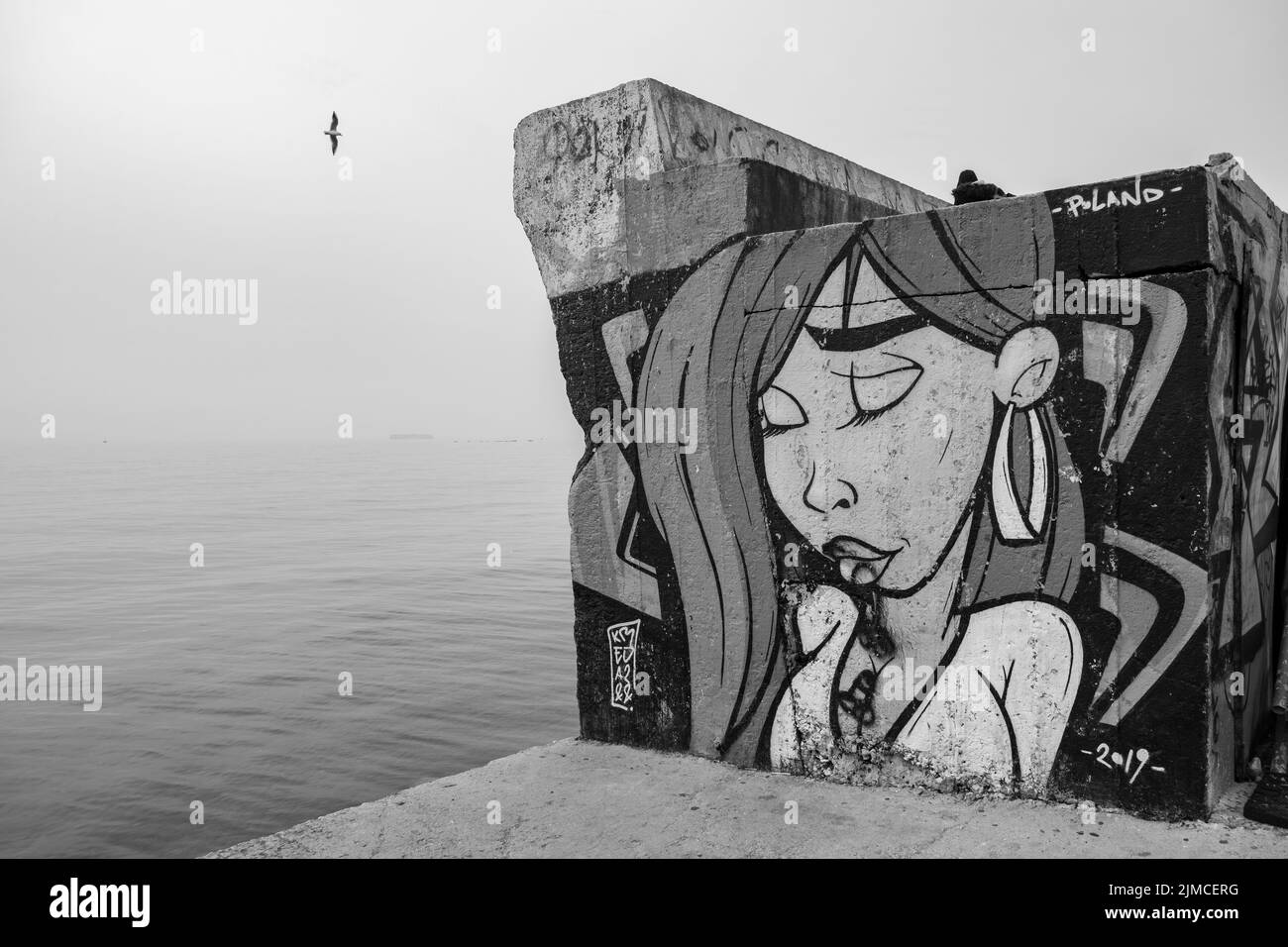Graffiti, das eine Frau auf einer Betonwand am Meer im Palaio Faliro in Athen, Griechenland, zeigt Stockfoto