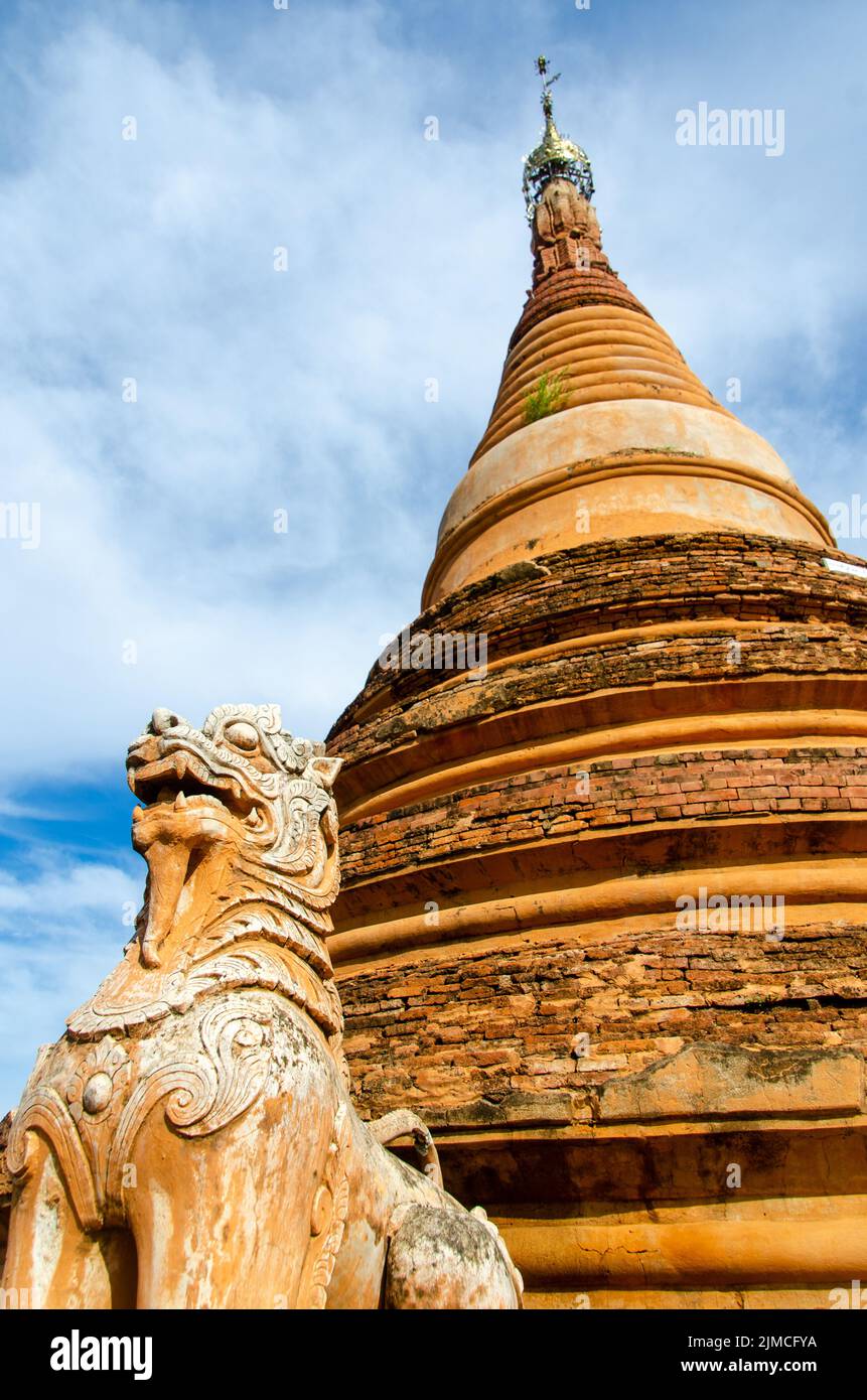 Brumesischer Löwe, der vor einer Stupa in Inwa steht Stockfoto