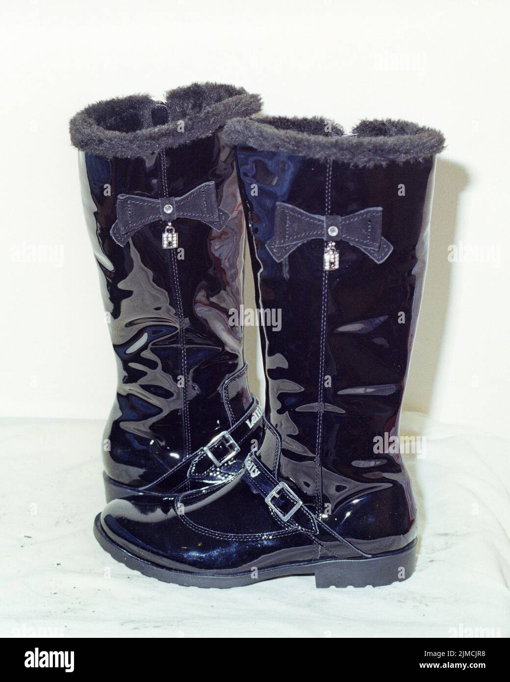 Bolton, UK - April 2022: Ein Paar schwarze Lelli Kelly Lackleder hohe Stiefel für Mädchen. Stockfoto