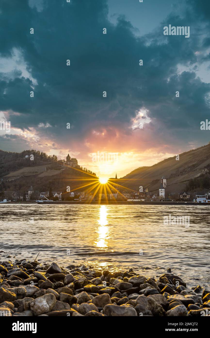 Sonnenuntergang über dem Rhein und das Stadtpanorama von Bacharach am Rhein, UNESCO Weltkulturerbe Oberes Mittelrheintal, Rheinland-Pfalz, Deutschland Stockfoto