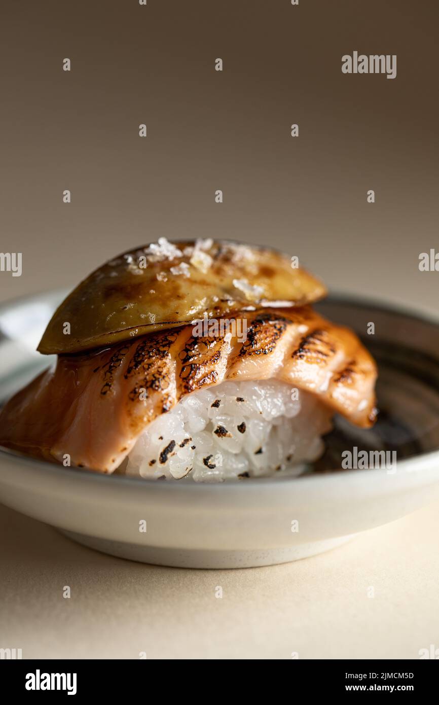 Im Restaurant wird leckeres japanisches, horwegisches Nigiri-Sushi mit geräuchertem Lachs und flambierten Foie Gras auf dem Teller serviert Stockfoto