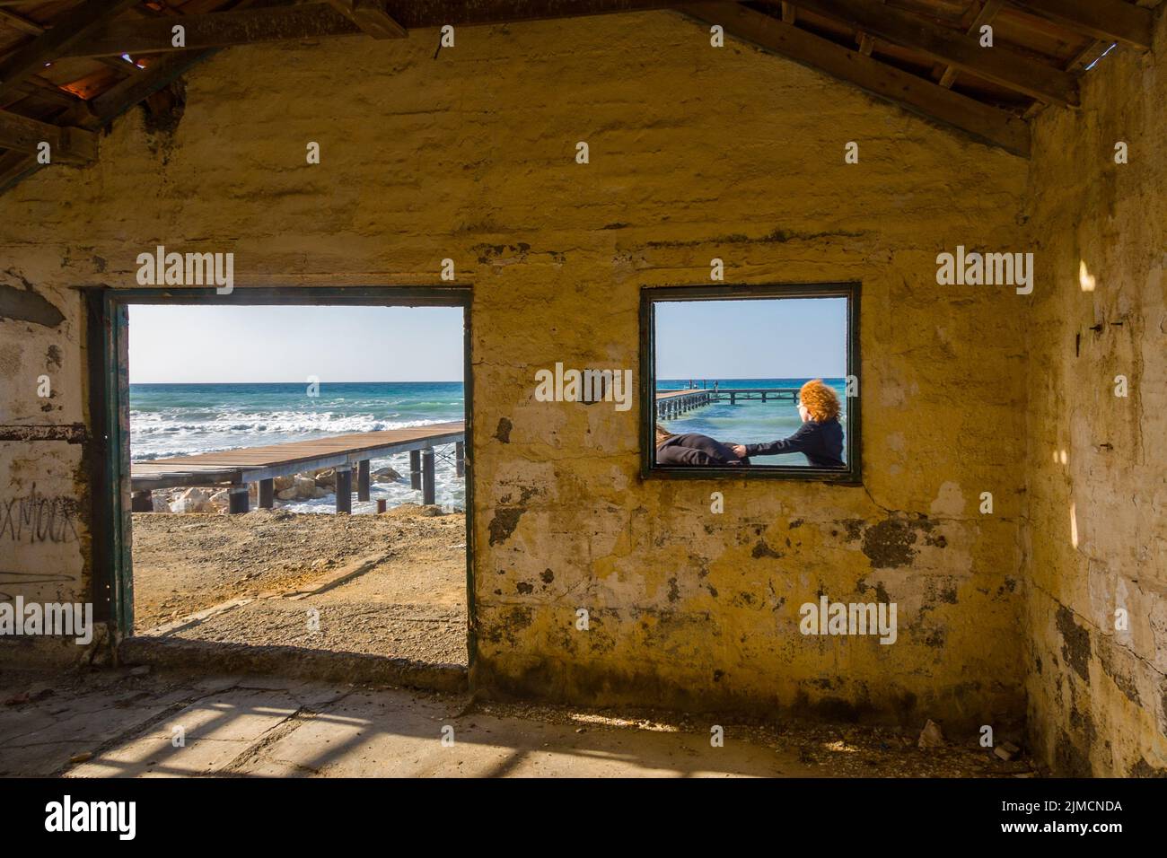 Pier und Menschen durch Fenster verlassene Gebäude in Argaka in Zypern. Stockfoto