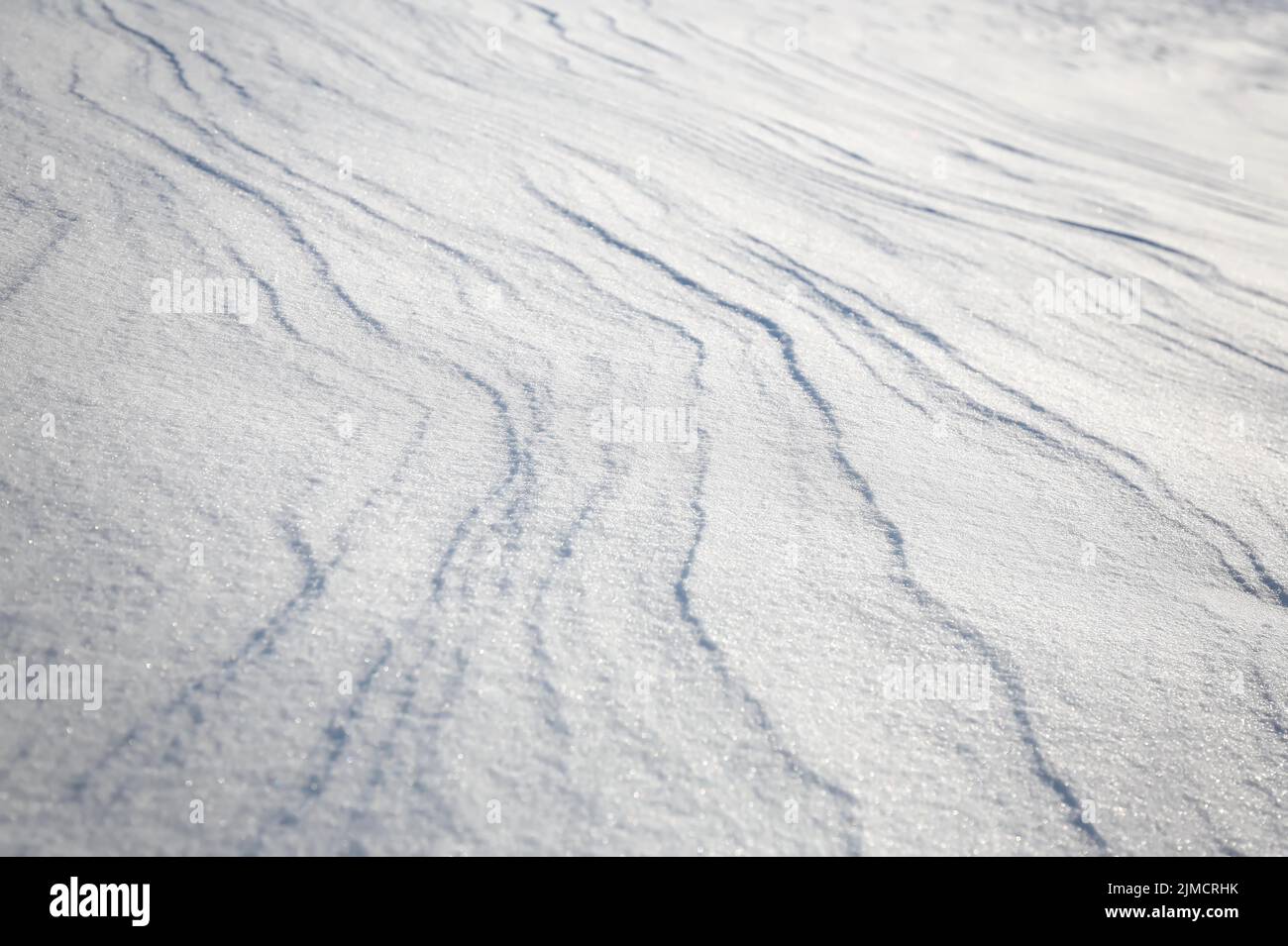 Schneeverwehungen, die durch den Wind aus Pulverschnee verursacht werden, wirken wie Dünen und bilden bizarre Muster und Strukturen Stockfoto