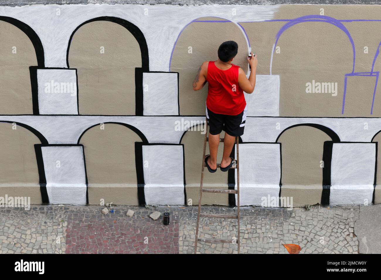 Mann malt Graffiti-Wandgemälde von Arcos da Lapa. Straßenkünstler schafft moderne Designarbeit Stockfoto