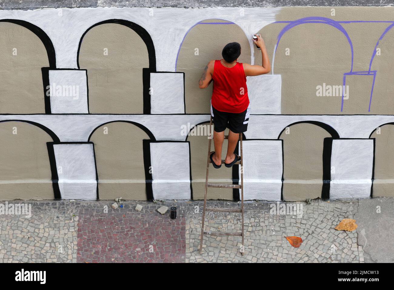Mann malt Graffiti-Wandgemälde von Arcos da Lapa. Straßenkünstler schafft moderne Designarbeit Stockfoto