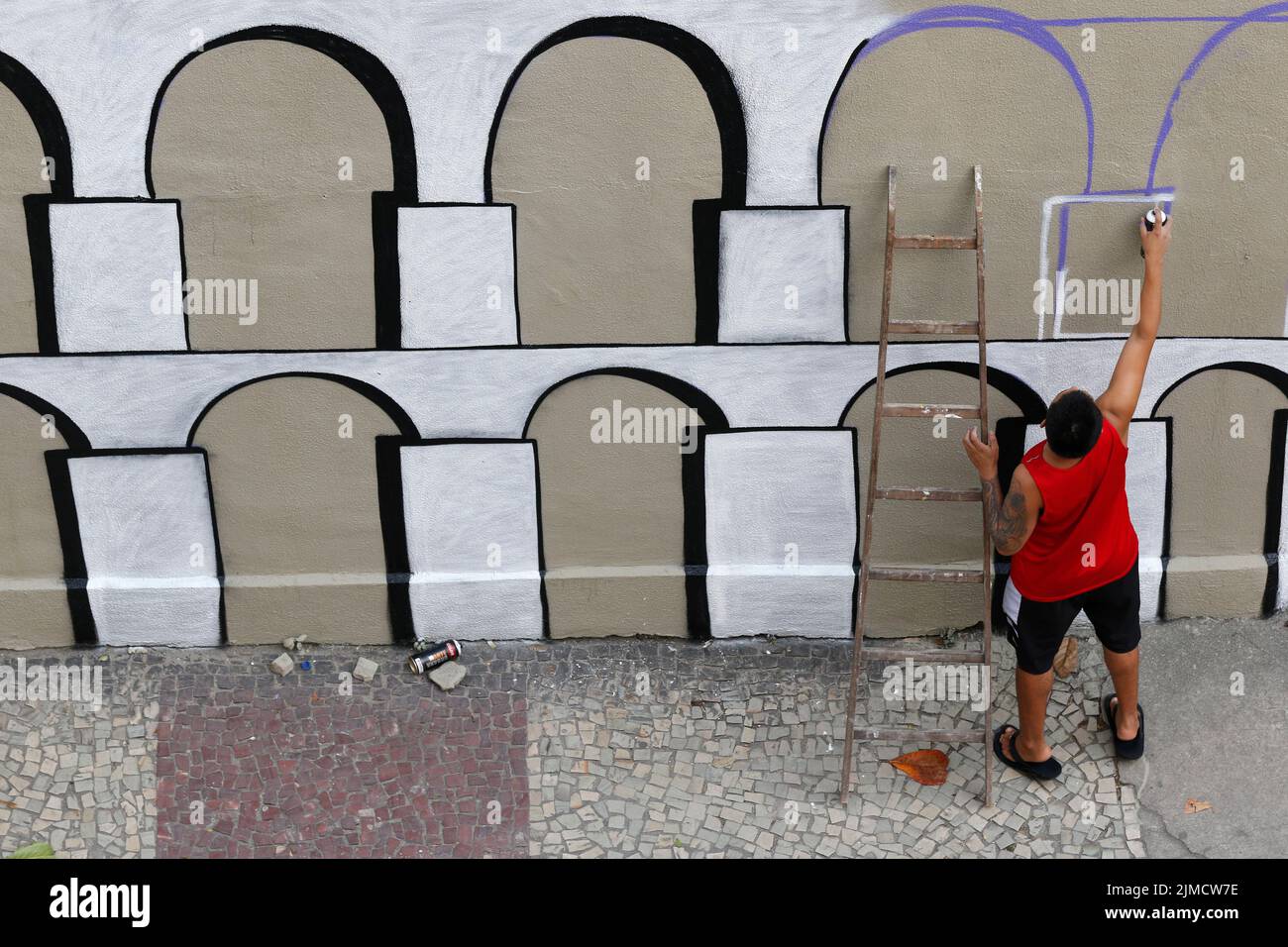 Mann malt Graffiti-Wandgemälde von Arcos da Lapa. Straßenkünstler schafft moderne Designarbeit Stockfoto