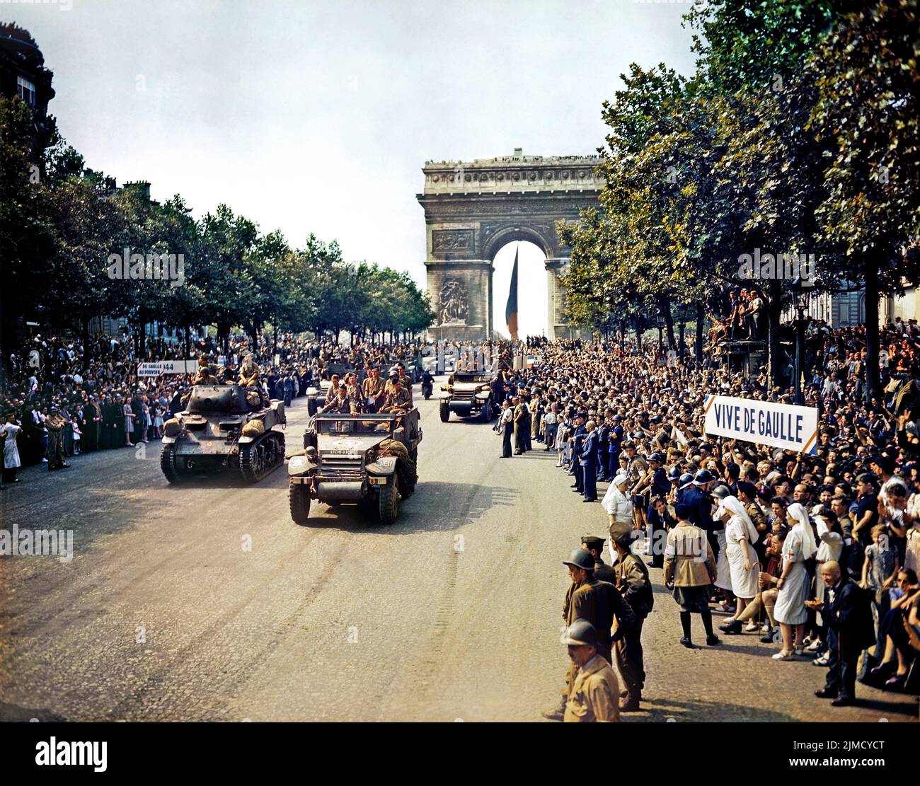 Massen von Franzosen säumen die Champs-Élysées, um die französischen 2e DB-Panzer und die halben Gleise zu sehen, die am 26. August 1944 vor dem Triumphbogen vorbeiführen. Stockfoto