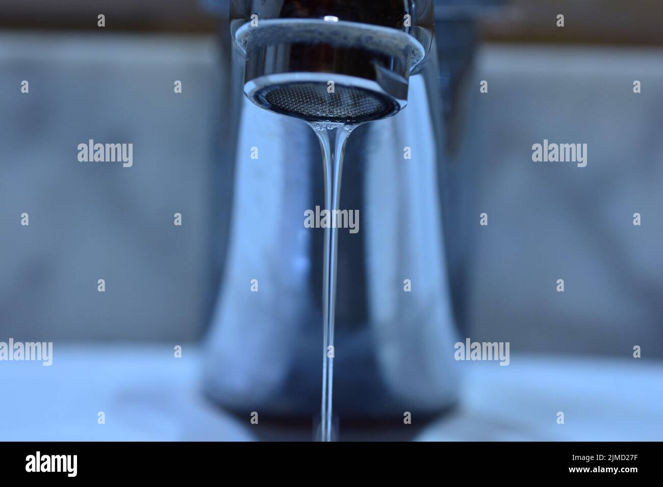 Pequeño chorro de agua cayendo de un grifo de un lavabo Stockfoto