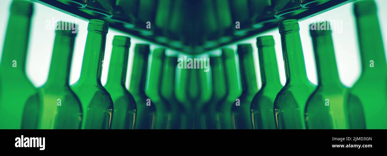 Reihe aus grünem Glas leere Weinflaschen Hälse in einem Spiegel reflektiert Stockfoto
