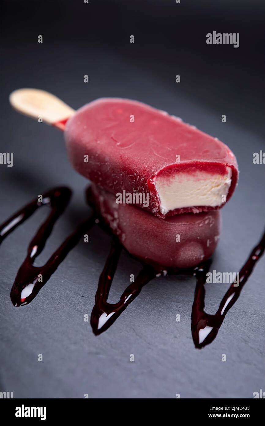 Fruchteis-Stick sieht frisch zu essen auf schwarz platziert Stockfoto