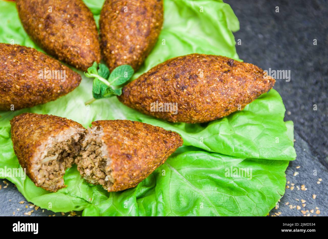 Köstliches libanesisches Essen, Spinat Sfiha mit Ricotta-Käse auf schwarzem Stein Hintergrund. Stockfoto