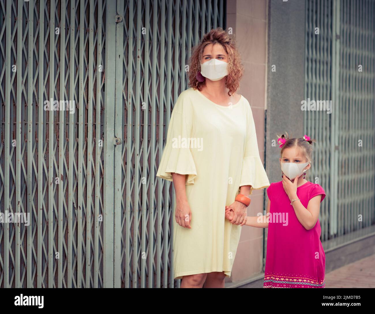 Frau und Tochter tragen eine Einweg-Gesichtsmaske. Coronavirus-Schutz Stockfoto