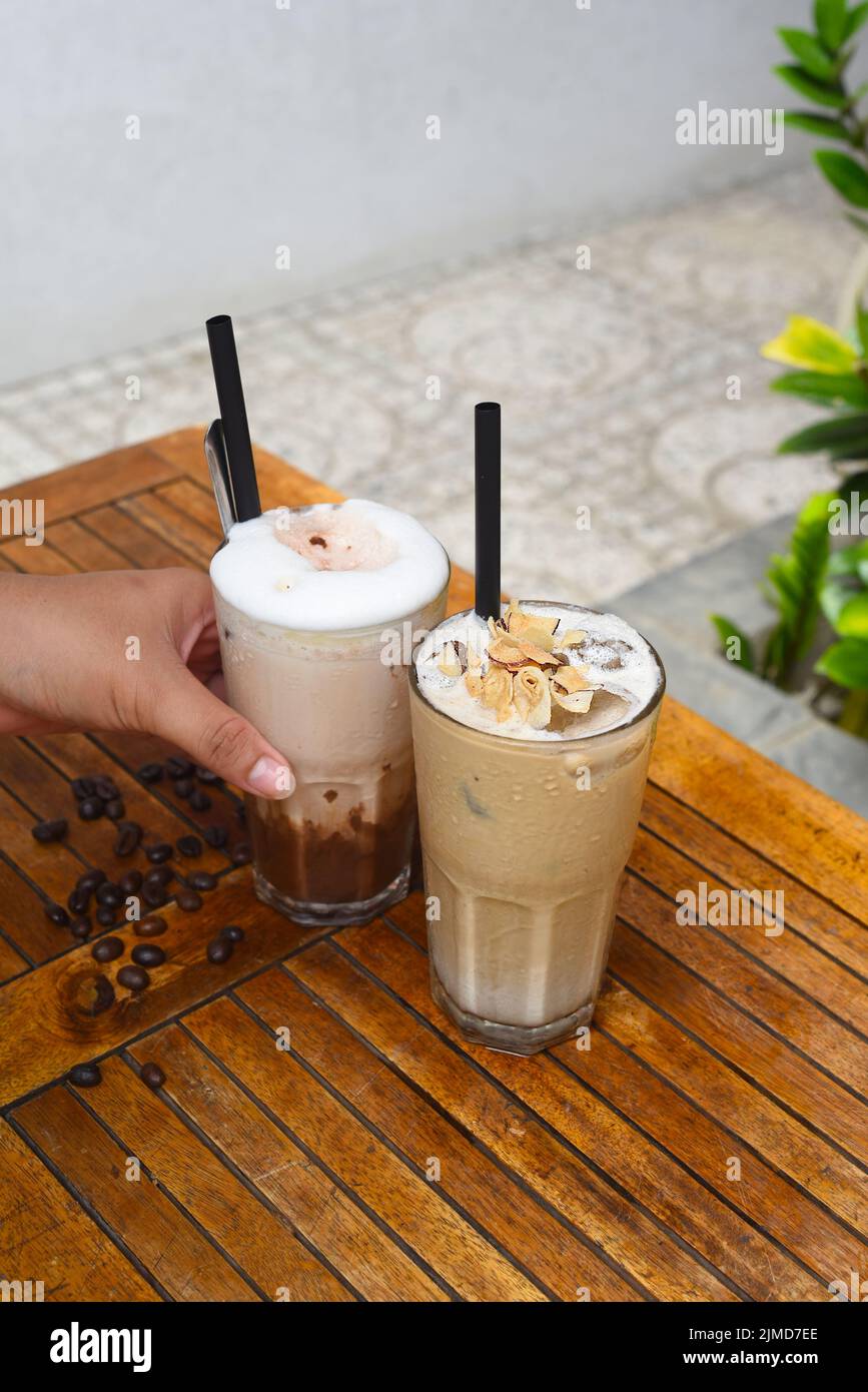Die Hand der Frau hält Kaffeegetränke Stockfoto
