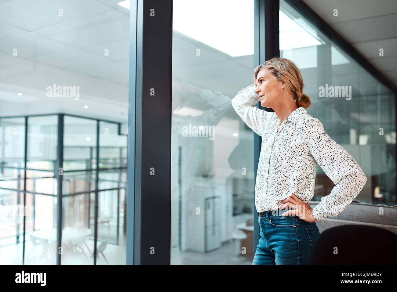 Gefühle von Unbehagen und Besorgnis schleicht sich in ihre Karriere. Eine reife Geschäftsfrau, die gestresst in einem Büro schaut. Stockfoto