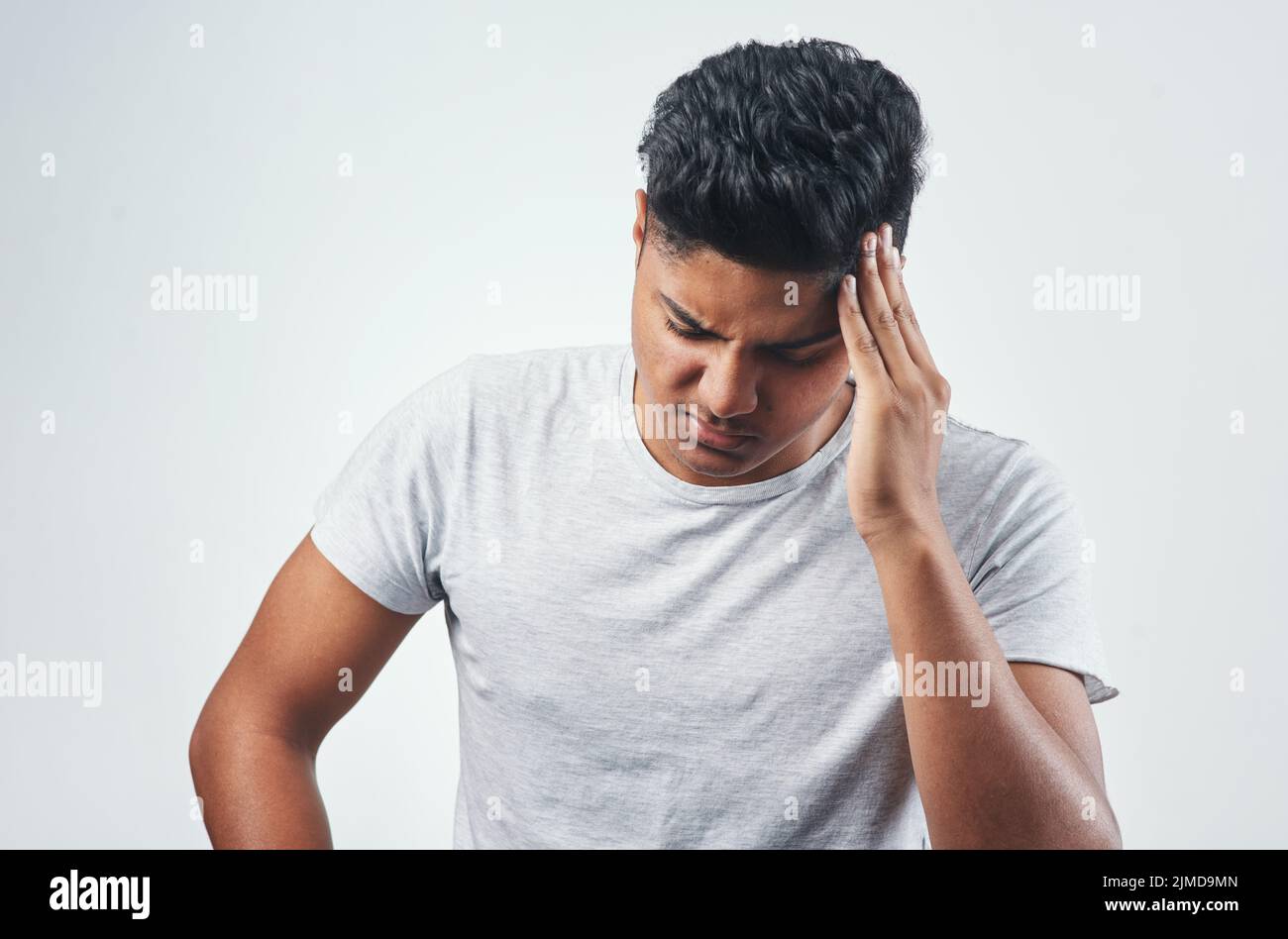 Ich halte es nicht mehr aus. Studioaufnahme eines jungen Mannes, der  Kopfschmerzen hat, während er vor weißem Hintergrund steht Stockfotografie  - Alamy