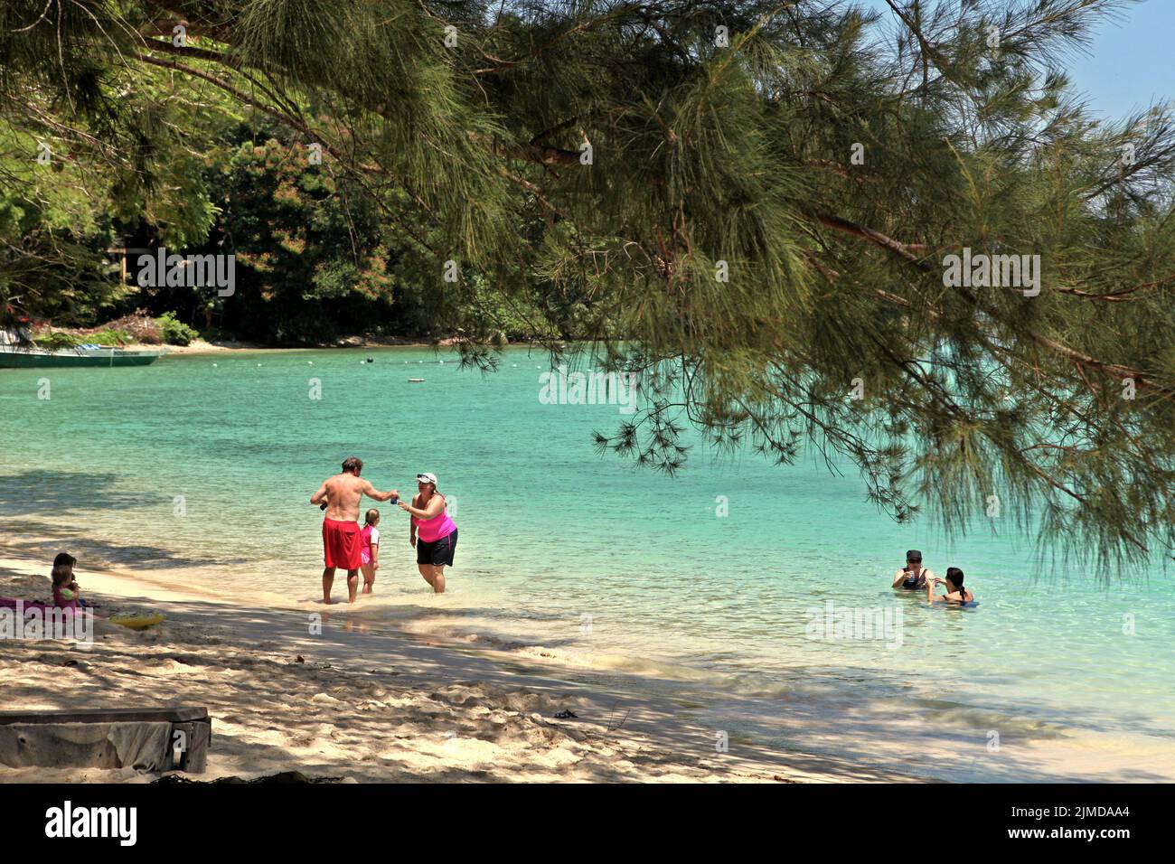 Besucher, die sich am Strand von Pulau Sapi (Sapi Island), einem Teil des Tunku Abdul Rahman Parks in Sabah, Malaysia, entspannen können. Stockfoto