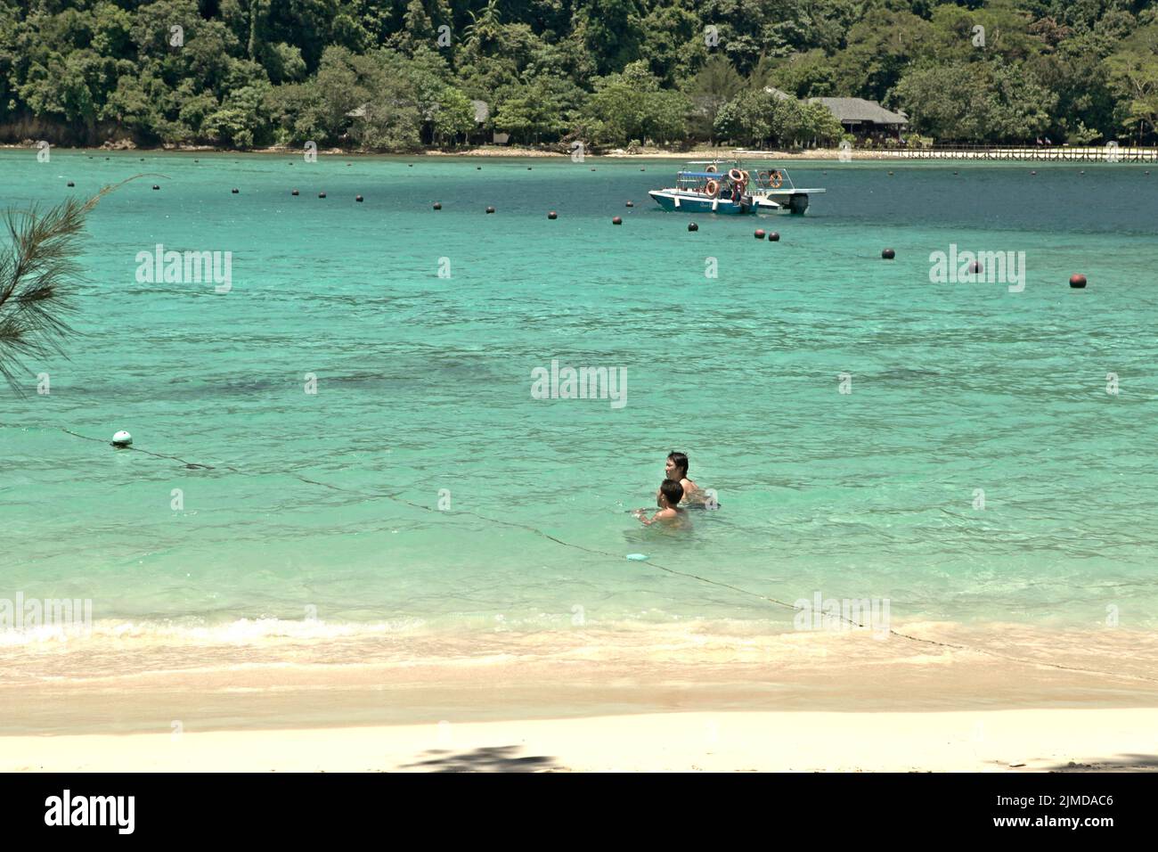 Besucher, die sich am Strand von Pulau Sapi (Sapi Island), einem Teil des Tunku Abdul Rahman Parks in Sabah, Malaysia, entspannen können. Stockfoto