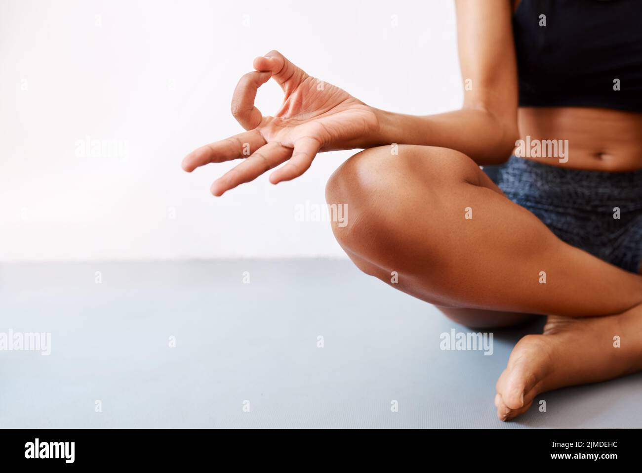 Yoga ist das, was mich beruhigt. Eine unkenntliche Frau, die vor weißem Hintergrund Yoga praktiziert. Stockfoto