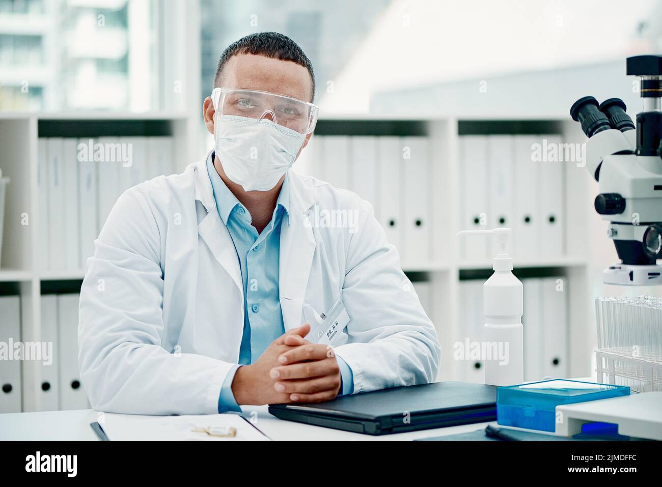 Vertuschen Sie sich, Ihre Sicherheit zählt darauf. Porträt eines jungen Wissenschaftlers, der einen Laptop benutzt, während er an einer Coronavirus-Heilung in einem Labor arbeitet. Stockfoto