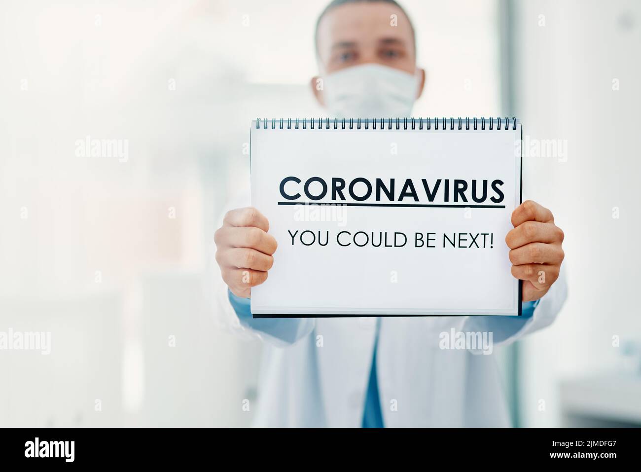 Dieses Virus unterscheidet nicht. Ein Wissenschaftler hält ein Zeichen mit CORONAVIRUS-SIE KÖNNTEN ALS NÄCHSTES in einem Labor sein. Stockfoto