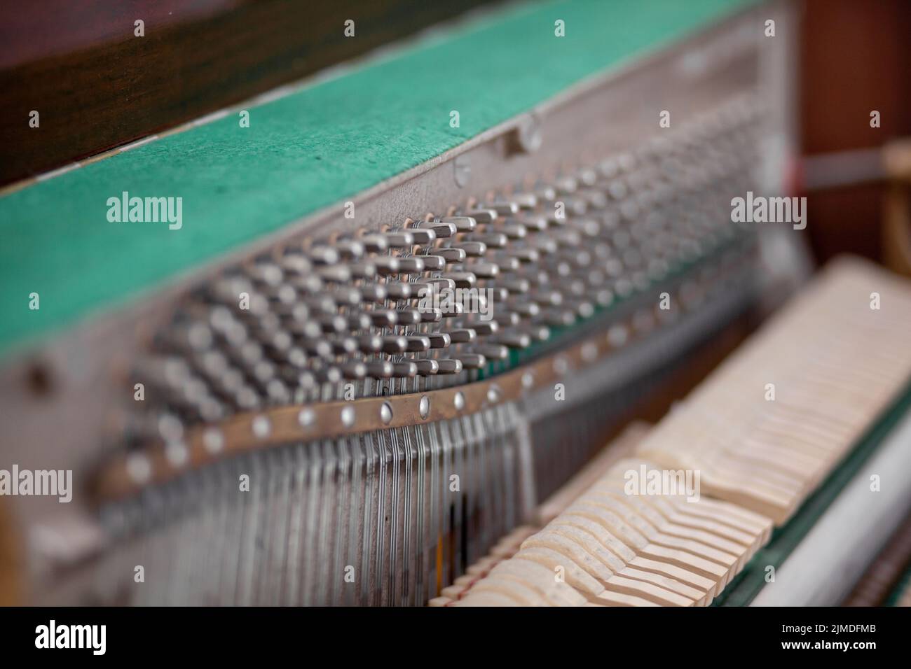 Das Innere des Klaviers ist ohne Deckel. Saiten, Hämmer und andere Teile eines Musikinstruments sind sichtbar. Tuning und Reparatur eines musikalischen Instrums Stockfoto