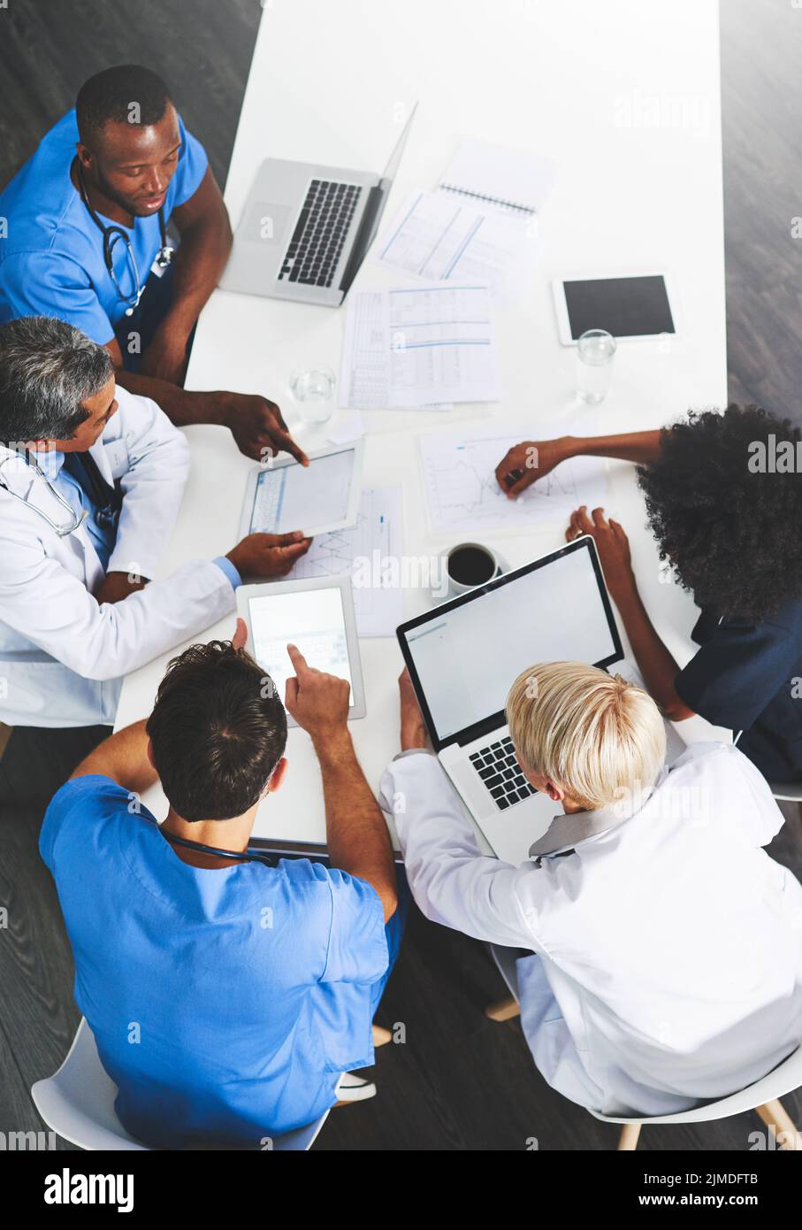 Ärzte, medizinische Fachkräfte oder Mitarbeiter im Gesundheitswesen mit einem Laptop sprechen, treffen oder planen medizinische Behandlung im Krankenhaus. Über der Ansicht der verschiedenen Gruppe Stockfoto