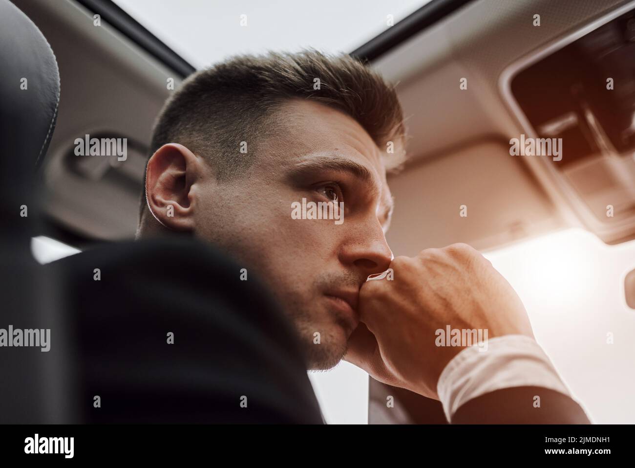 Schöner Geschäftsmann am Steuer an sonnigen Tagen Stockfoto