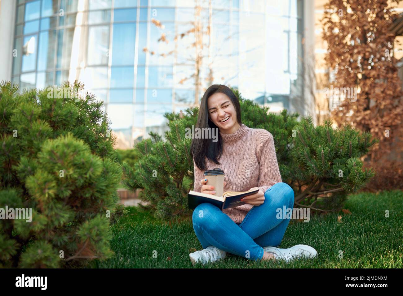Sorglose junge Frau mit viel Spaß beim Lesen humorvolle Geschichte Stockfoto