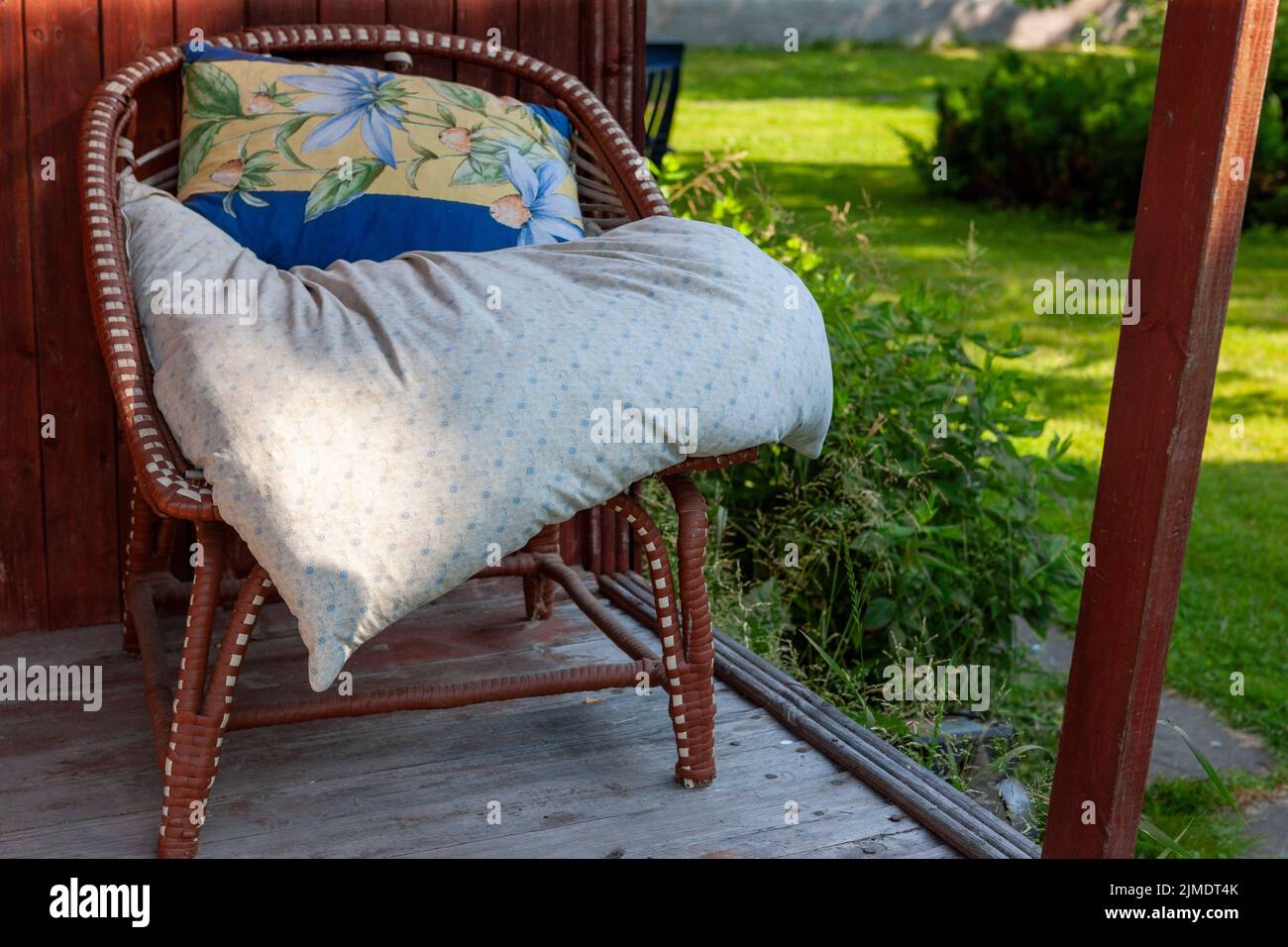 Ein Kissen auf einem Sitz aus gemütlichen Sessel auf der Veranda platziert, im Freien sonnig Tagesaufnahme Stockfoto