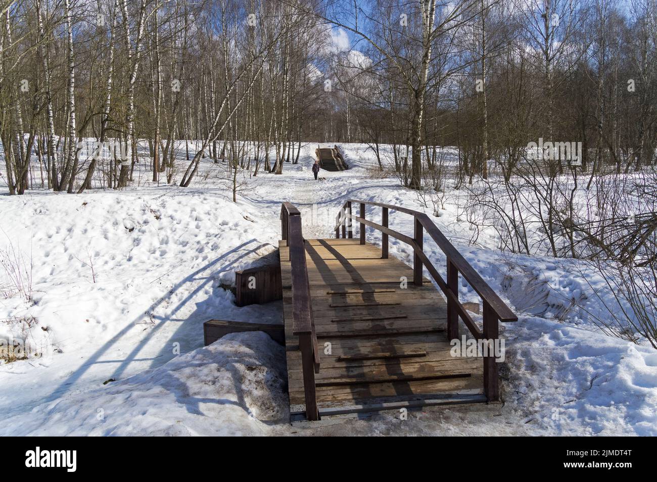 Eine Brücke über einen Bach am Fuße einer kleinen Schlucht. Stockfoto
