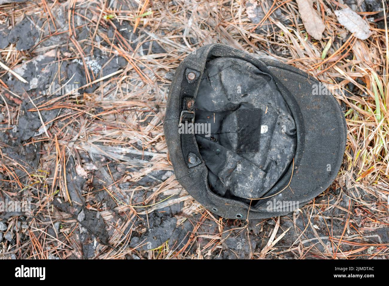 Alte schmutzige Kappe auf dem Boden weggeworfen, Nahaufnahme im Freien Stockfoto