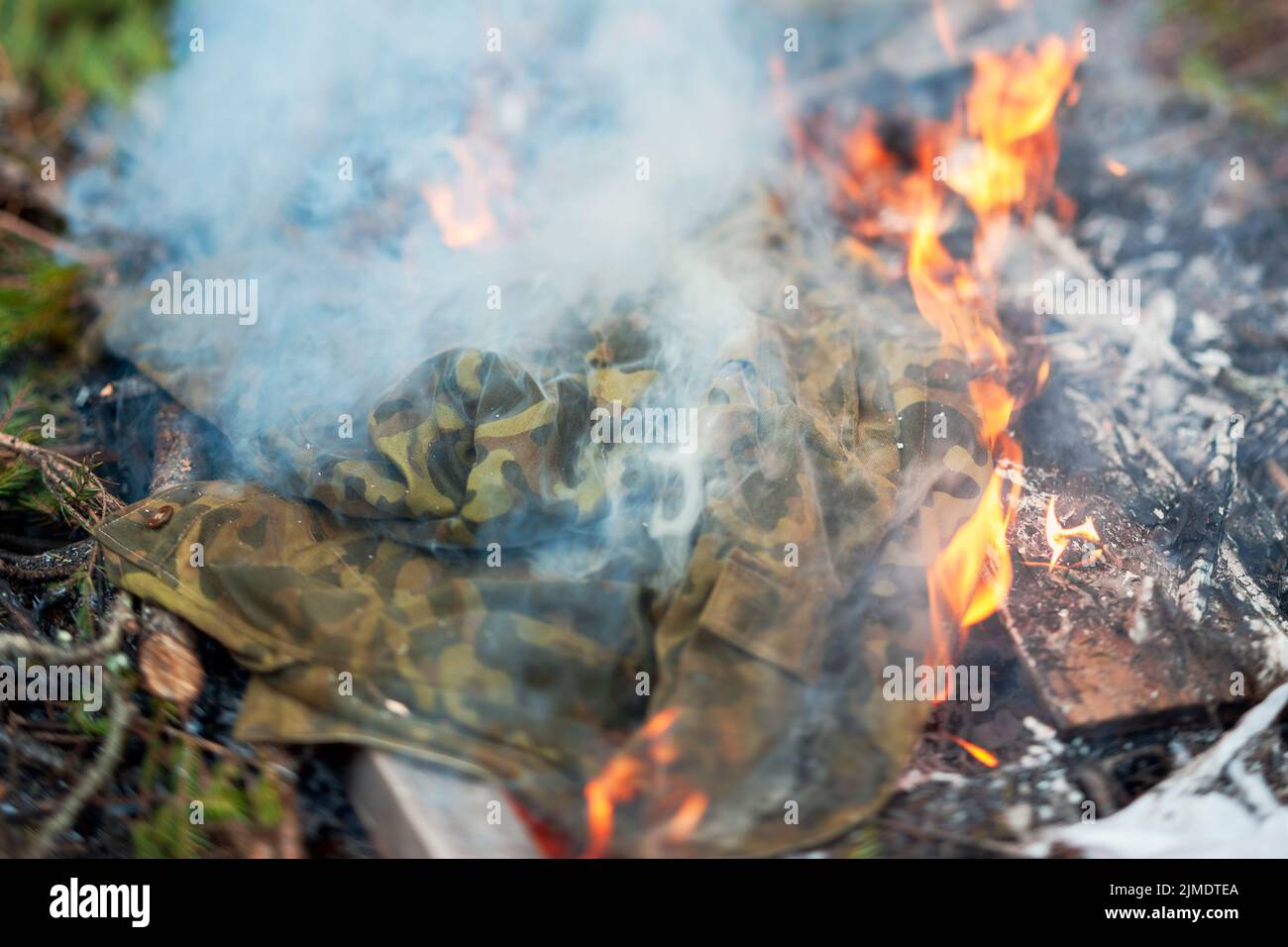 Nahaufnahme einer brennenden Tarnuniform im Feuer, Außenaufnahme Stockfoto
