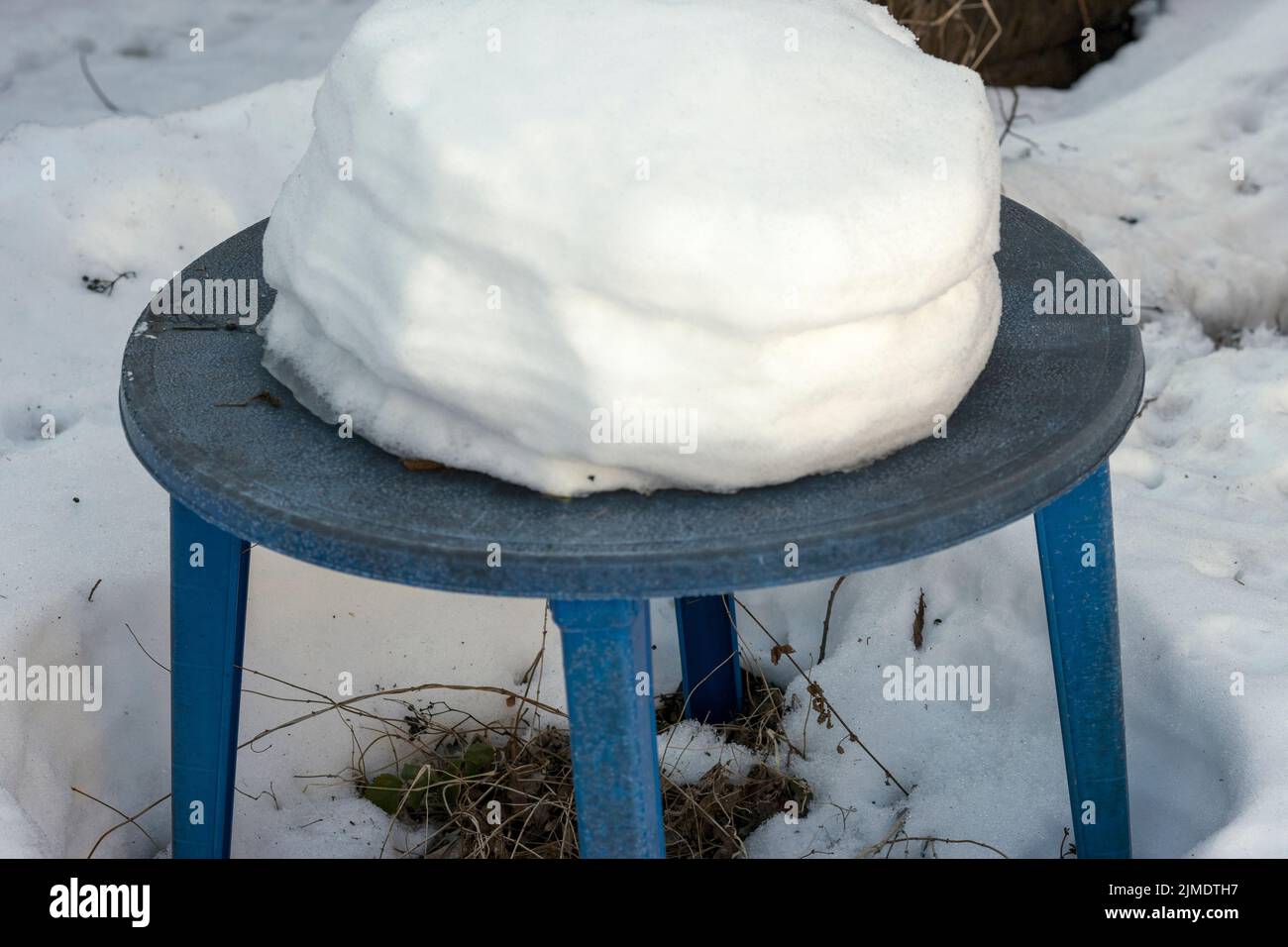 Verlassene Garten Kunststoff-Tisch mit einer Schneeverwehung auf der Oberseite, Winterszene Stockfoto