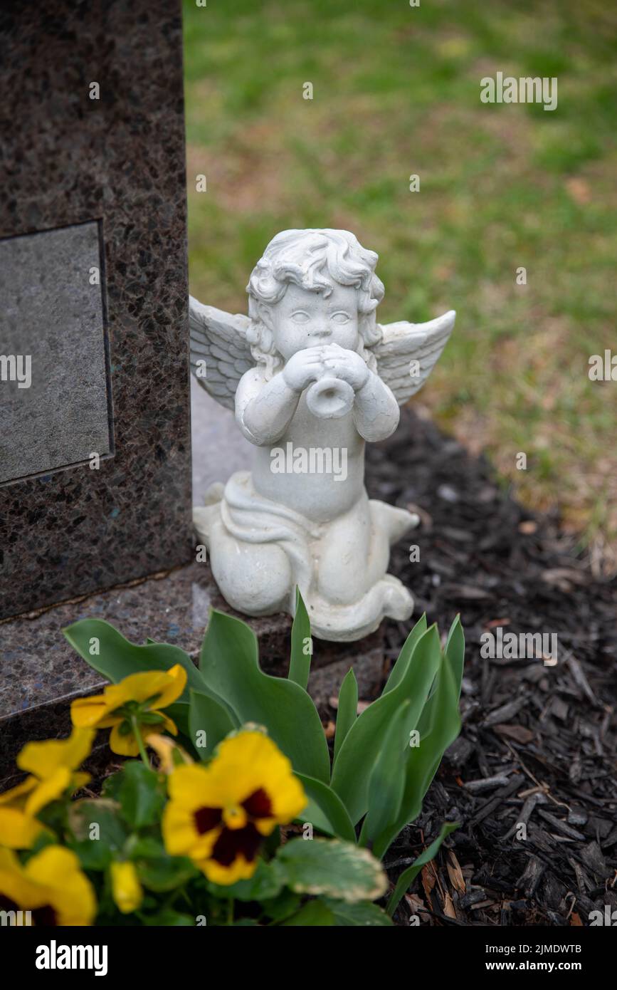 Der Engel des Friedhofs spielt die Trompete auf einem Grabstein Stockfoto