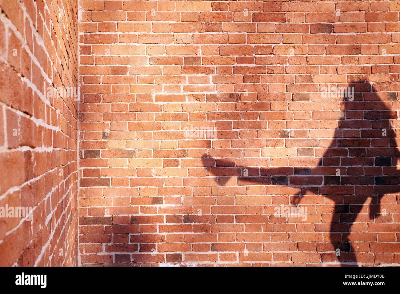 Schatten eines Mannes auf einem Backsteinmauer Hintergrund Stockfoto