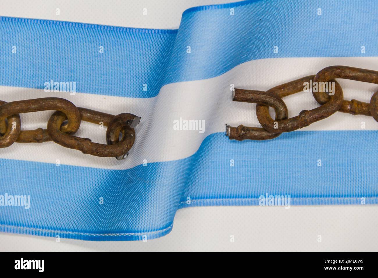 Gebrochene Ketten auf der argentinischen Flagge. Konzept der Revolution und der nationalen Unabhängigkeit Stockfoto