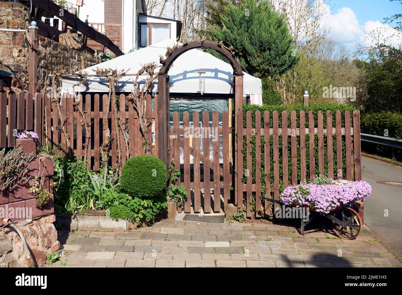 Blumen in einer alten roten Schubkarre aus Eisen. Stockfoto