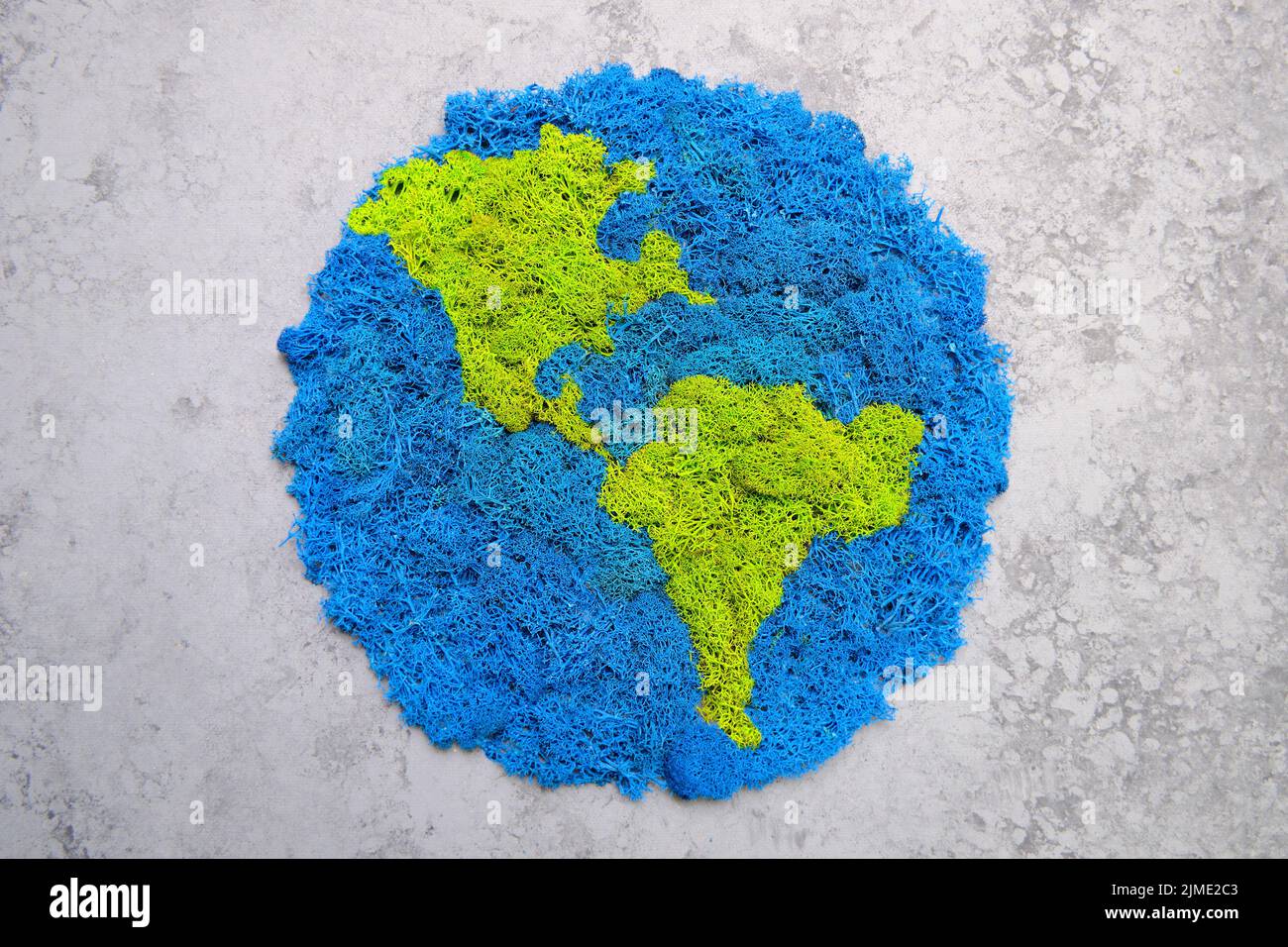 Planet Erde und Kontinente, stabilisiertes gemaltes Moos, grauer Hintergrund Stockfoto