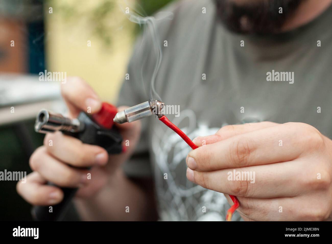 Der Typ heizt den Draht. Teile reparieren Stockfoto