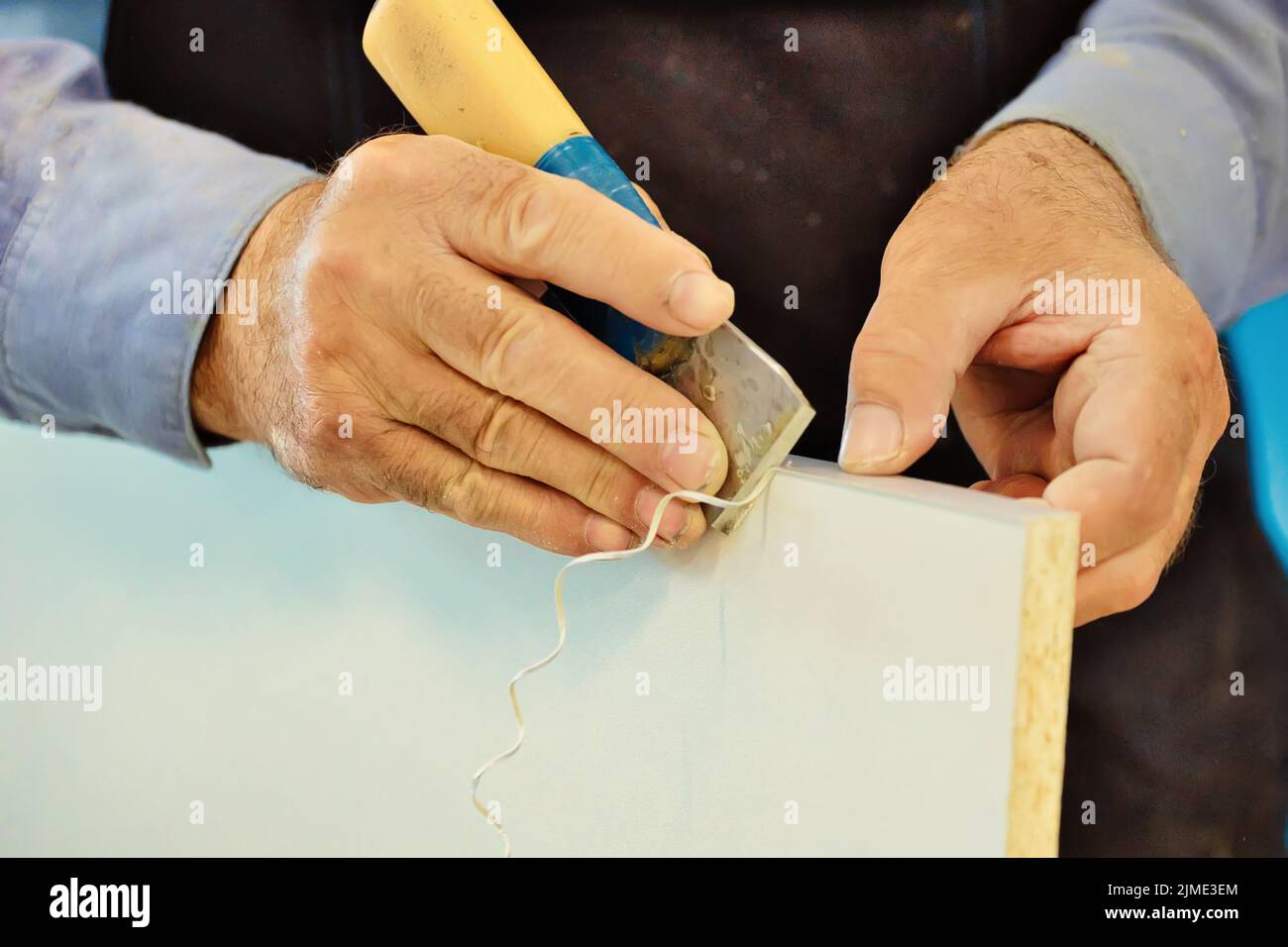 Die Hände eines älteren Zimmermanns und ein Werkzeug während der Nahaufnahme. Stockfoto