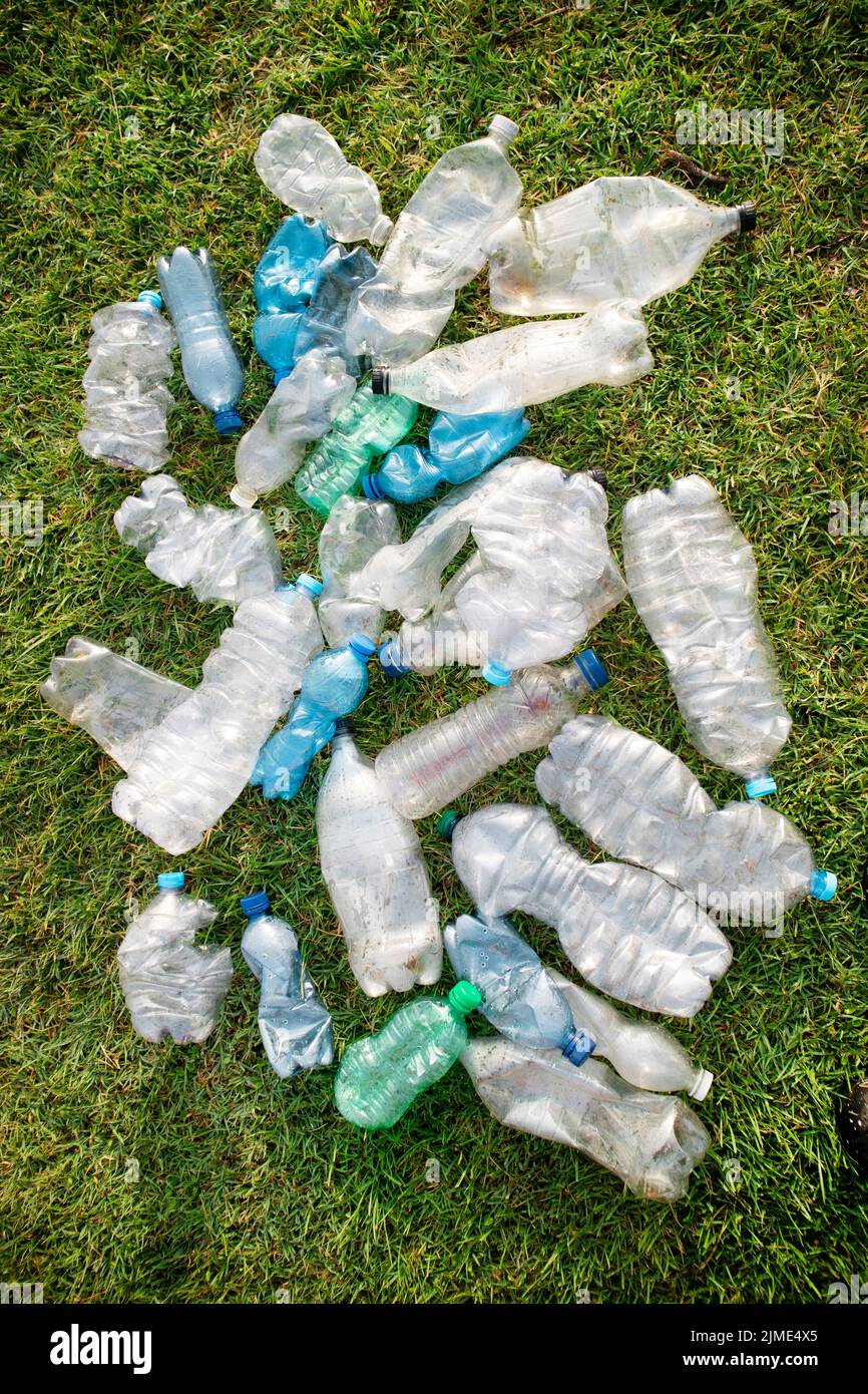Gebrauchte Plastikflaschen, die auf einer Wiese aufgegeben wurden Stockfoto