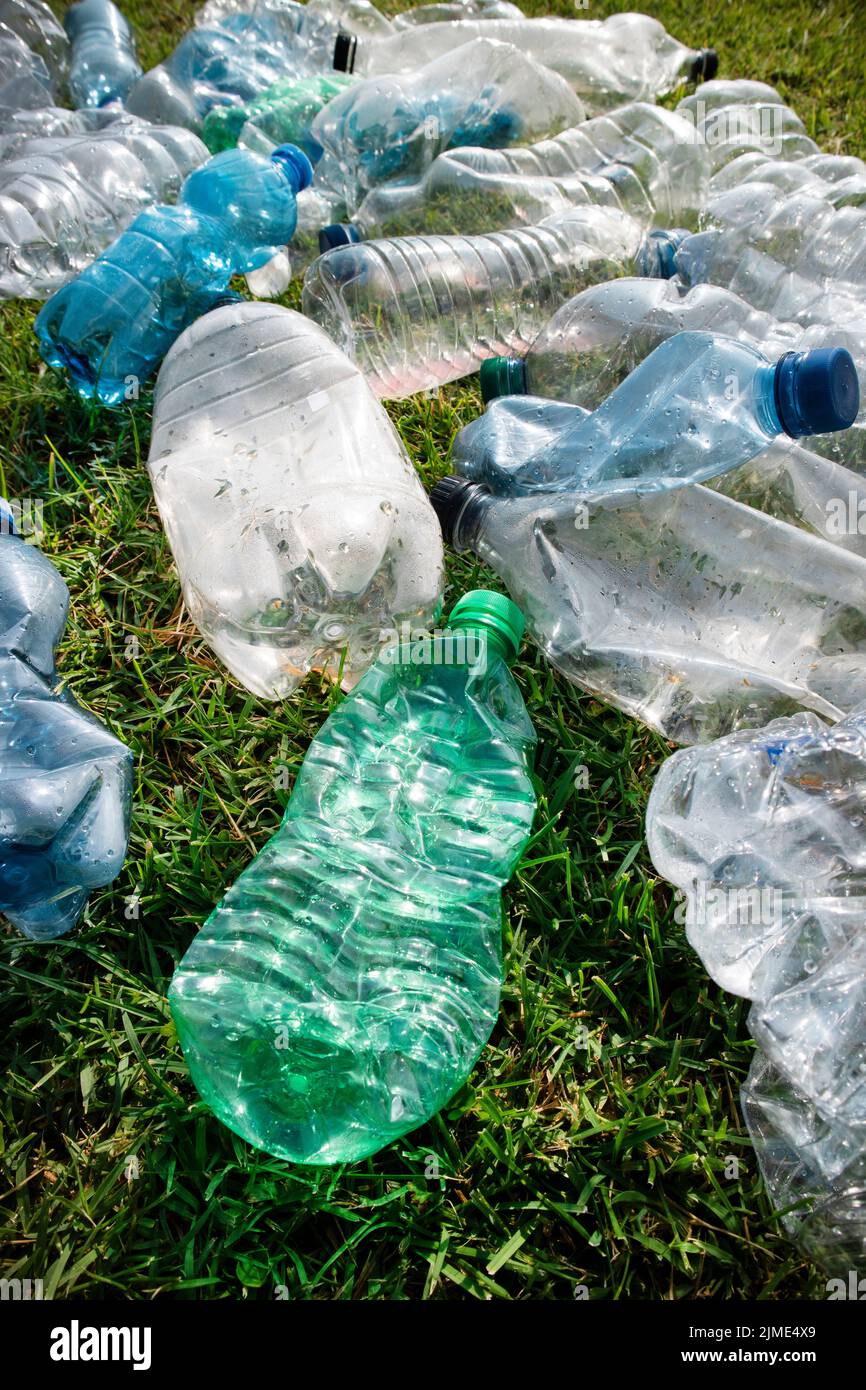 Gebrauchte Plastikflaschen, die auf einer Wiese aufgegeben wurden Stockfoto